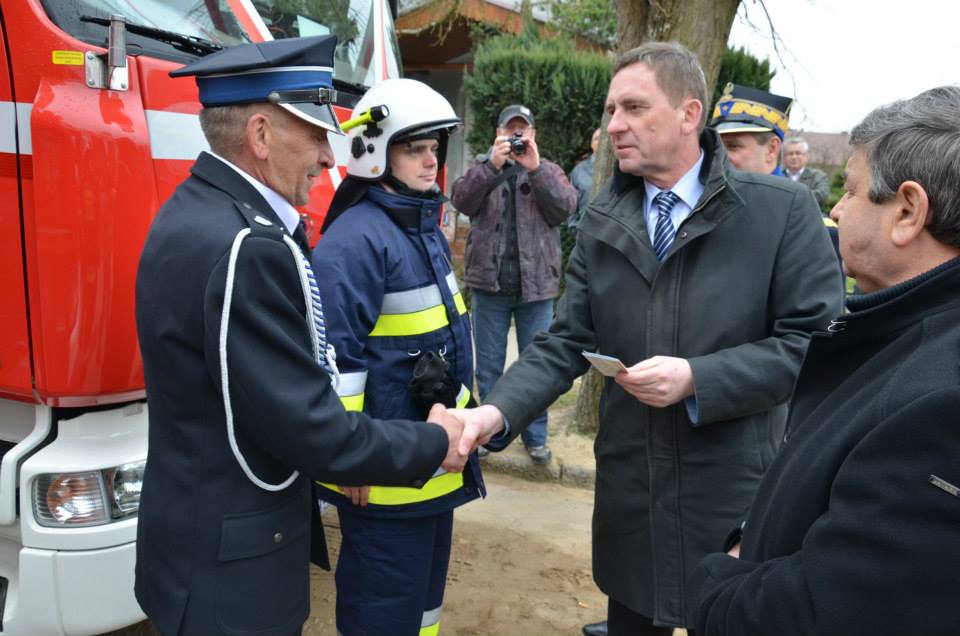 Wicemarszałek Województwa Zachodniopomorskiego Andrzej Jakubowski przekazuje kluczyki i dokumenty do jednego z czterech zakupionych wozów strażackich.