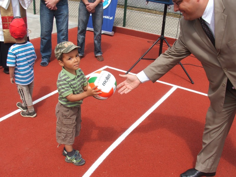 Wicemarszałek Witold Jabłoński rozdaje dzieciom piłki