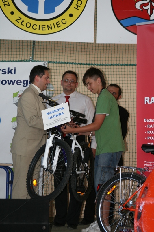 Wojciech Drożdż przekazuje nagrodę zwycięzcy konkursu z wiedzy drogowej.