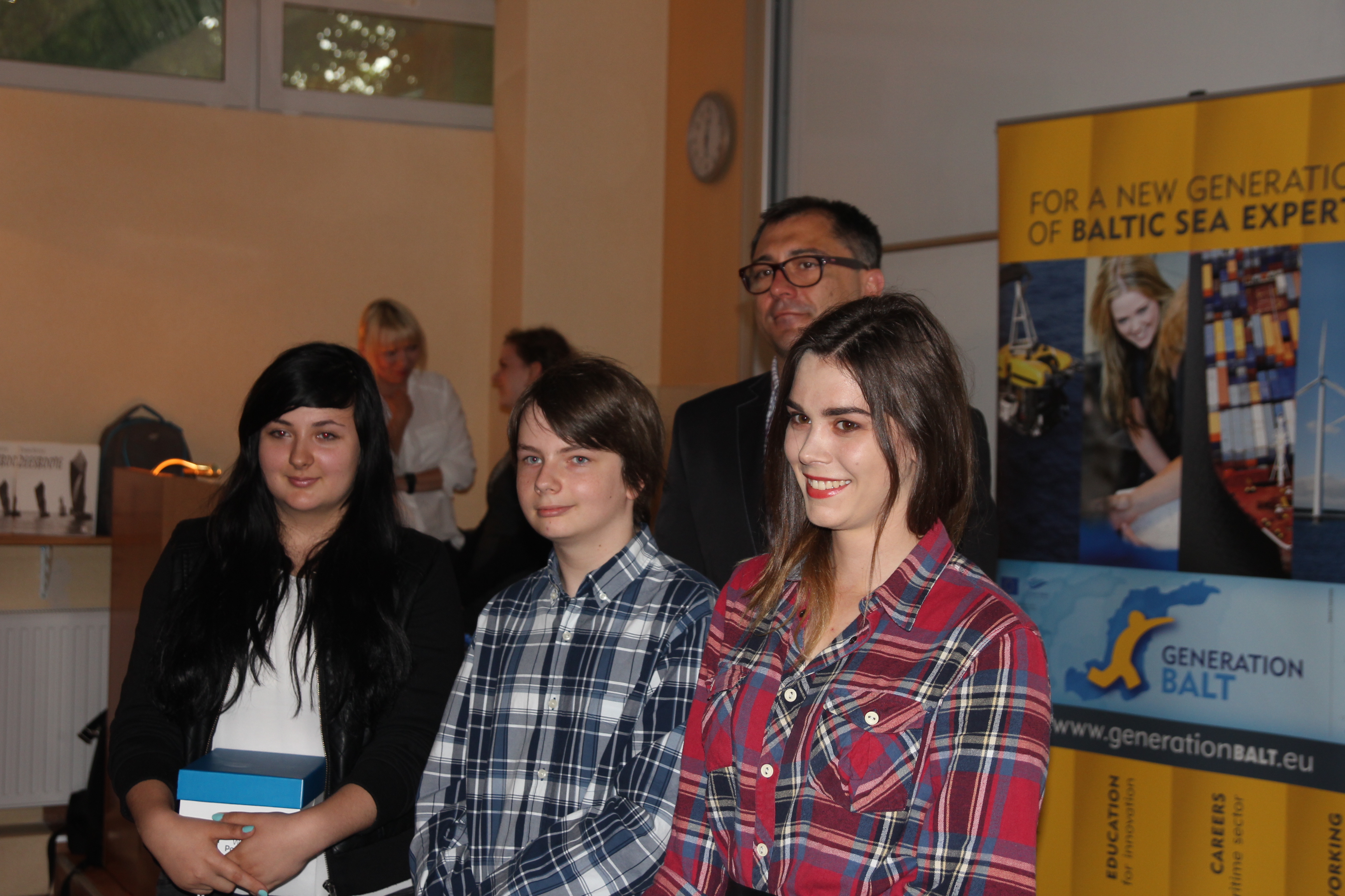 Dyrektor generalny urzędu Przemysław Włosek wraz z laureatami konkursu Selfie z Morzem.