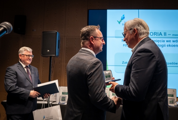 Drugi laureat odbiera nagrodę na scenie.