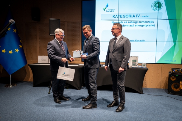Nagrodę na scenie odbiera prezydent Koszalina Tomasz Sobieraj, w tle ekran z logo i nazwą konkursu. 