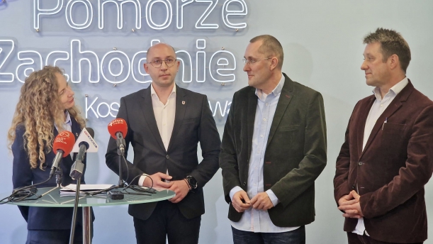 wspólne zdjęcie gości konferencji prasowej w urzędzie marszałkowskim w biurze w Koszalinie, goście stoja przy stoliku koktajlowym, na stole ustawione są mikrofony