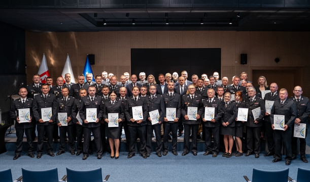 Wszystkie dofinansowane OSP prezentują odebrane certyfikaty wsparcia do wspólnego zdjęcia, w tle scena i ekran.