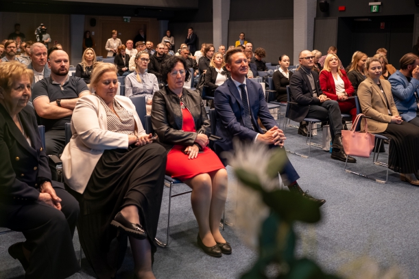 Ważne seminarium dla kadr medycznych. Uczestnicy seminarium siedzą na sali, w rzędach, około 100 osób.
