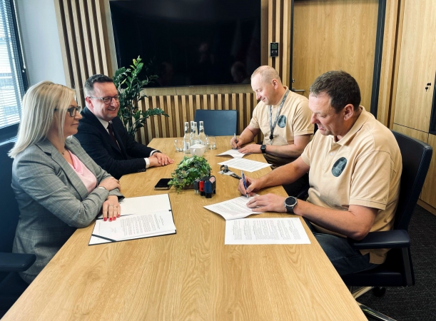 Dotacja dla POSP „Tryton” w Kołobrzegu. Sygnatariusze umowy podpisują porozumienie przy stole prezydialnym.