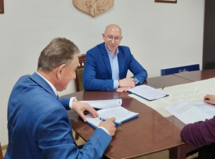 wicemarszałek Jakub Kowalik i burmistrz polanowa podpisują umowę w gabinecie, na stole leżą dokumenty