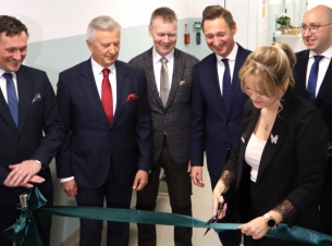 Goście uroczystego otwarcia przecinają wstęgę, w tle pomieszczenia SOR w koszalińskim szpitalu. 