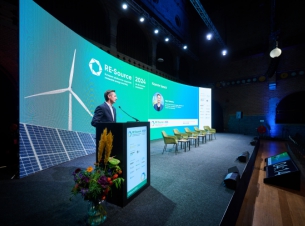 Marszałek Geblewicz stoi na scenie i przemawia przy mównicy do uczestników forum - fot. Gregory De Leeuw.  