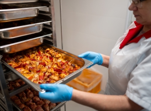 kucharka wkłada do pieca mięso 