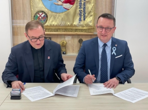 podpisanie umowy w caritas przez ks. Szmuca i czł. Zarządu Bogdana Jaroszewicza