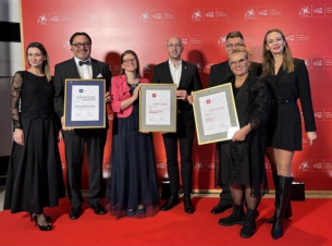 Zachodniopomorsy laureaci gali POT pozują z nagrodami do wspólnego zdjęcia, w tle czerwona ścina. 