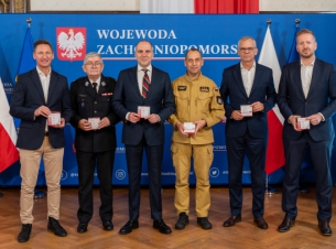 Uczestnicy konferencji prasowej prezentują czujki dymu, które trafią do mieszkańców regionu - fot. Zachodniopomorski Urząd Wojewódzki. 