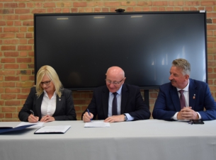 Strony umowy przy stole prezydialnym podpisują porozumienie - fot. starostwo Powiatowe w Wałczu