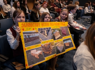 uczennice trzymają duży plakat z napisem: Szkoła Podstawowa Słoneczna – „Słoneczny ogród – dla ducha i ciała”