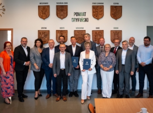 Wspólne zdjęcie samorządowców zrobione na tle ścianki