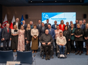 Uczestnicy gali podczas wspólnego zdjecia prezentują przyznane nagrody, w tle telebim