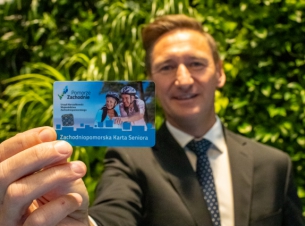 marszałek trzyma Zachodniopomorską Kartę Rodziny na tle zielonej ścianki