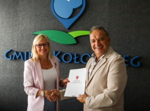 Beneficjenci pokazują podpisaną umowę.