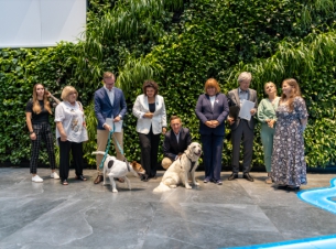 wspólne zdjęcie grupowe gości spotkaniana zielononej ściance w urzędzie marszałkowskim, marszałek głaszcze psa 