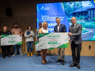 Laureatka z Białego boru i marszałkowie podczas wręczenia czeku, w tle ekran z tytułem wydarzenia.