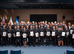 Wszystkie dofinansowane OSP prezentują odebrane certyfikaty wsparcia do wspólnego zdjęcia, w tle scena i ekran.