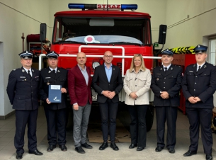 zdjęcie wicemarszałka z bneficjentami w remizie, stoja przed sachodem star 