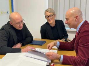 wicemarszałek Kowalik i burmistrz gminy przeglądają dokumenty, obok siedzi kobieta 