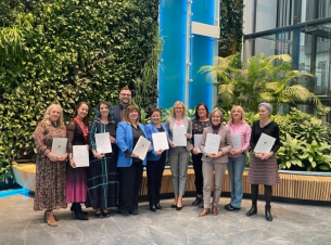 wspólne zdjęcie Rady ds. Rodziny w Urzedzie Marszałkowskim. Członkinie Rady stoja na tle zielonej ścianki