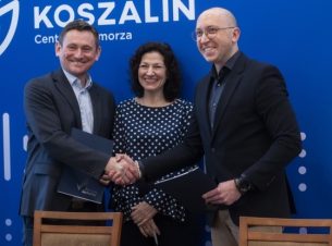 Wicemarszałek Kowalik i prezydent Sobieraj gratulują sobie podpisana porozumienia, w tle ścianka promocyjna Miasta Koszalin. 