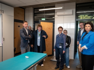 marszałek wraz z gośćmi stoi w sali zabiegowej schorniska, goście stoją i rozmawiają 