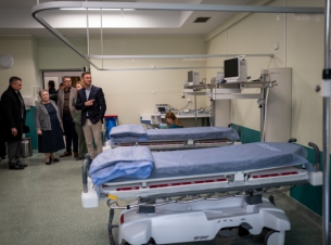 Uczestnicy zwiedzania SOR-u oglądają pomieszczenia dla pacjentów, na zdjęciu widać m.in. łózka i aparaturę medyczną. 
