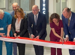 Goście uroczystości przecinają wstęgę,w tle pomieszczenia SOR-u.