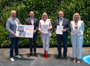 zdjęcie grupowe beneficjentów i wicemarszałków na tle zielonej ścianki