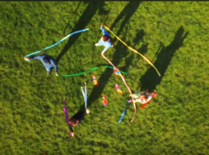 Kadr z „Somewhere Over the Rainbow” zrobiony na Jasnych Błoniach, ujęcie z drona pokazujące tańczących ludzi 