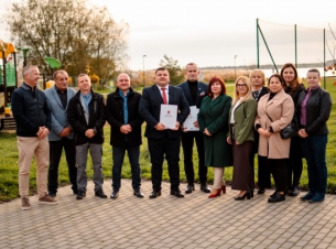 Sygnatariusze porozumienia prezentują podpisany dokument, w tle otoczenie jeziora Miedwie w Wierzbnie. 