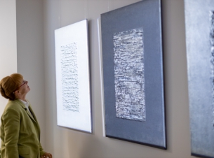 uczestnik wernisażu ogląda obrazy w Galerii M