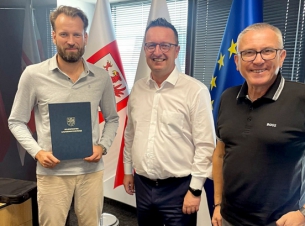 Sygnatariusze umowy gratulują sobie podpisania dokumentu.