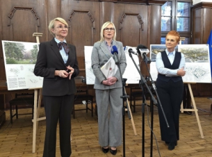 Strony porozumienia prezentują podpisany dokument, w tle wystrój ratusza i wizualizacje miejsca po zmianach. 