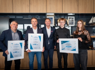 zdjęcie gości spotkania; w środku stoi marszałek, kadra klubu trzyna w dłoniach czeki rozmairu XXL