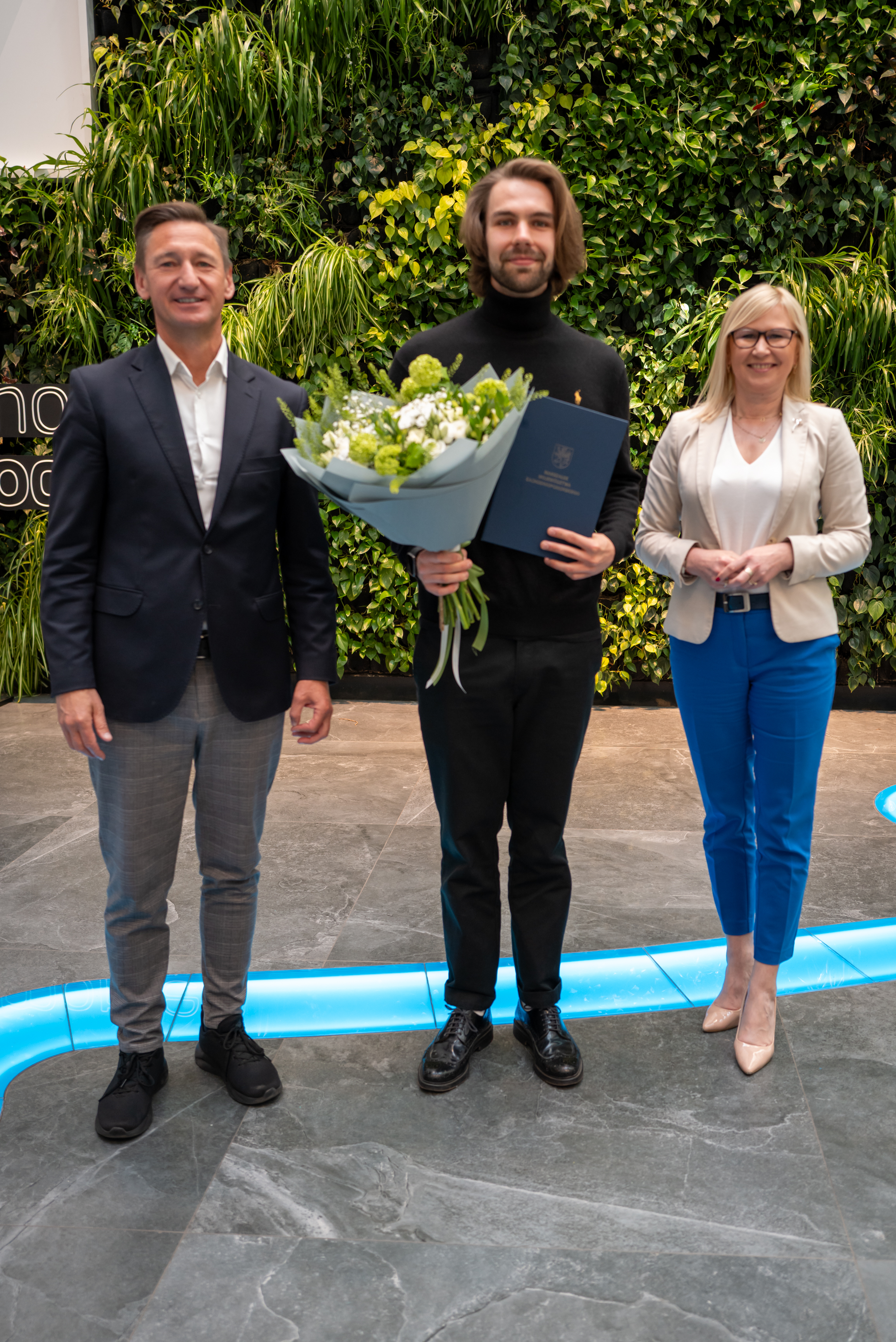 Marszałek i wicemarszałkini stoją z stypendystą