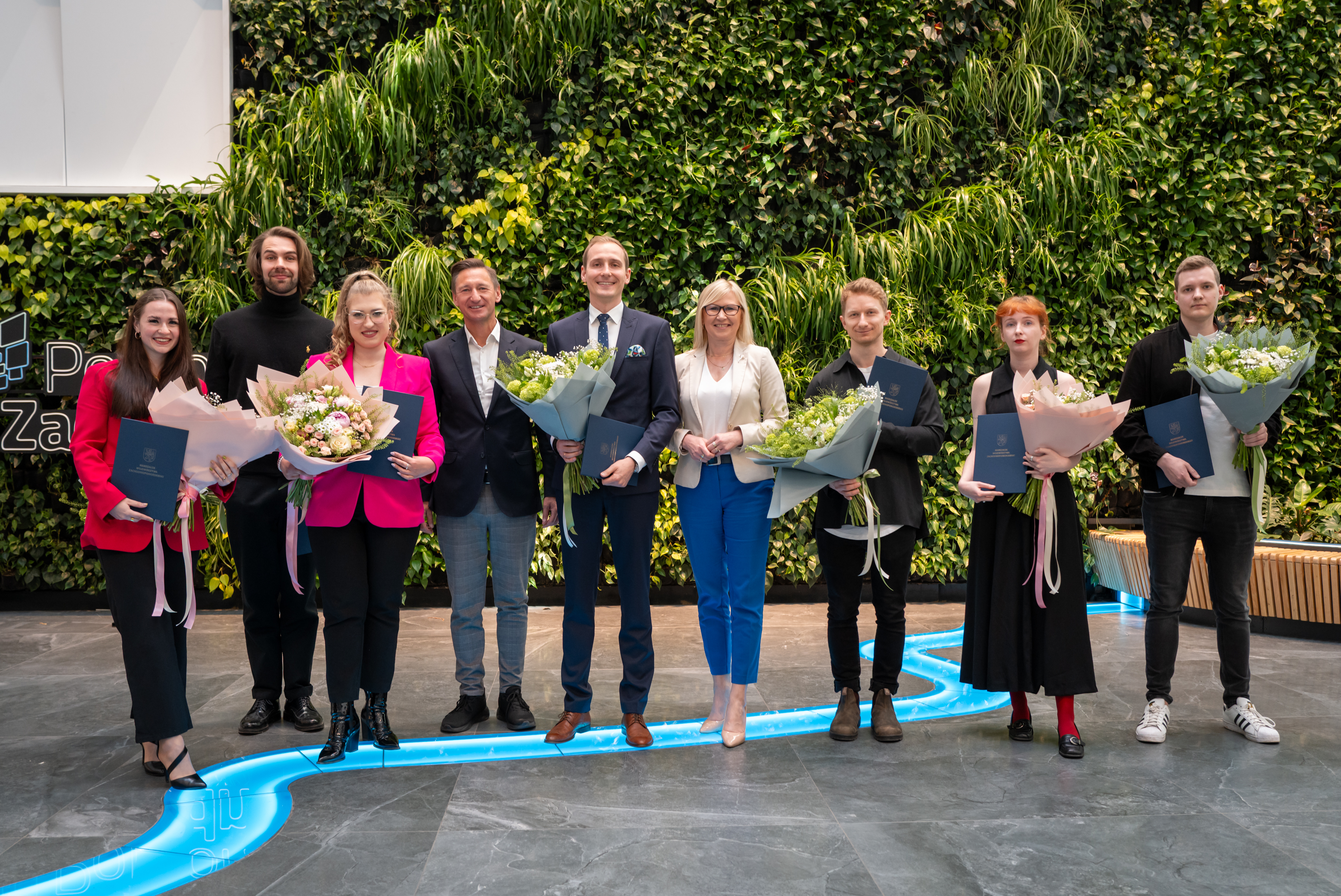 marszałek stoi z tegorocznymi stypendystami