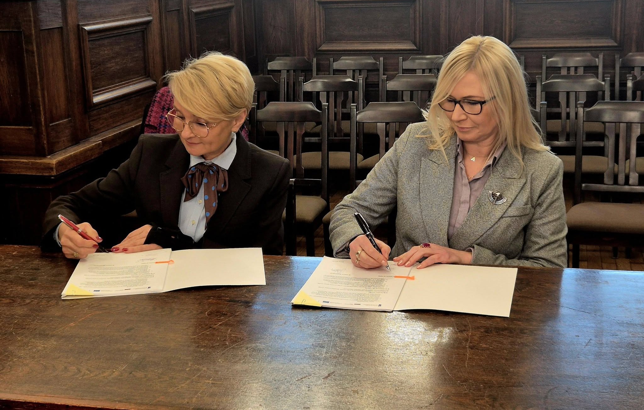 Unijna dotacja dla Kołobrzegu na rewitalizację Skweru Pionierów. Strony podpisuja porozumienie, w tle wystrój ratusza.